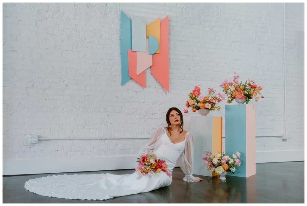 woman sits in gown with long train by The Hazel Club