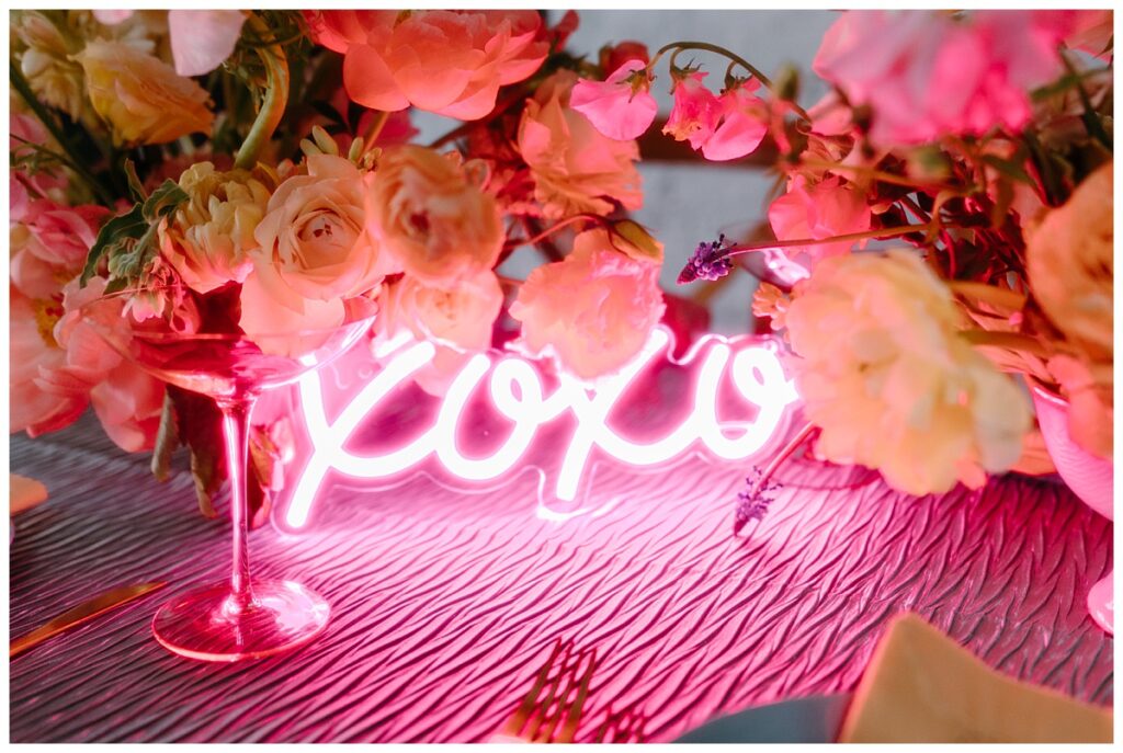 neon sign sits among floral centerpieces by Charlotte wedding photographer