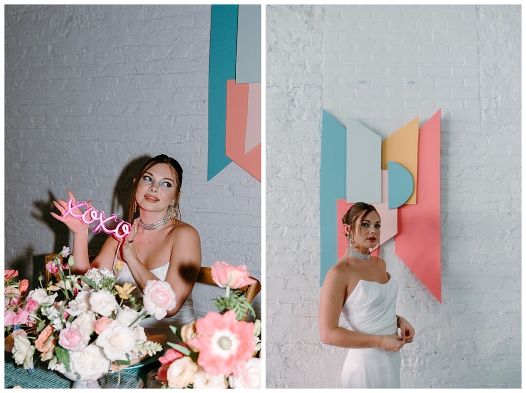woman holds neon sign seated at table with floral centerpieces by The Hazel Club
