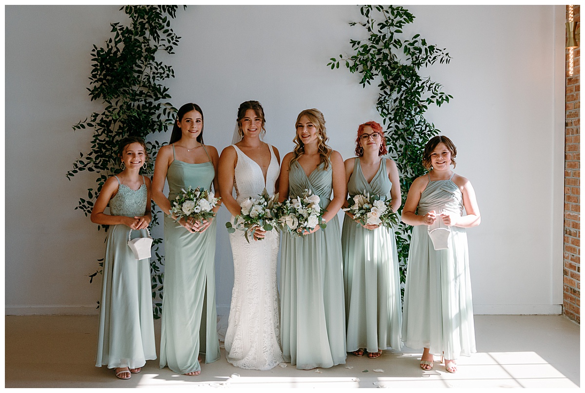 bridesmaids stand together with florals by The Hazel Club