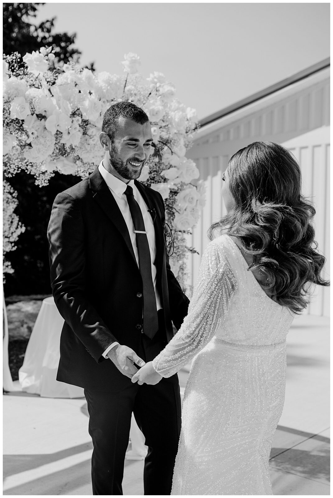 bride and groom share first look before modern barn ceremony